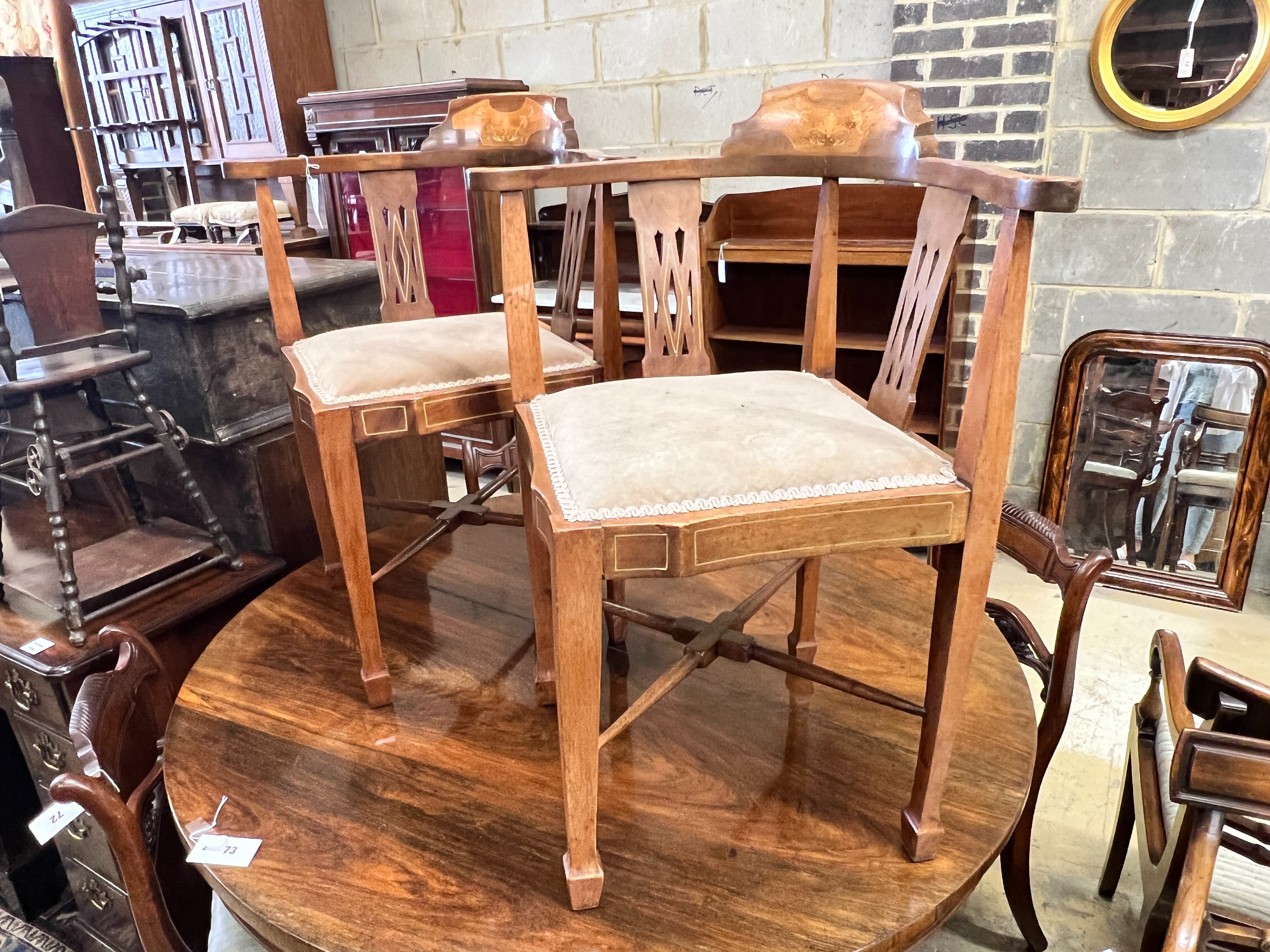A pair of Edwardian inlaid mahogany corner elbow chairs